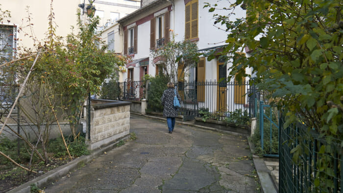 image, woman walking quiet street paris, unique travel experiences