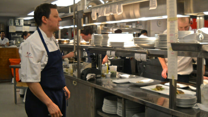 Eating alone but with others at a chef's table.