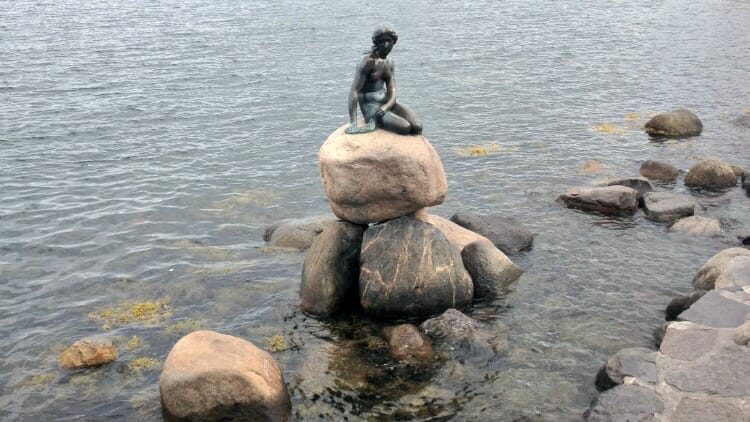 The little mermaid statue is popular with tourists who love to take photos. 