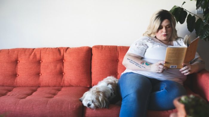when you can't travel, you can read about it, like this woman on sofa with dog