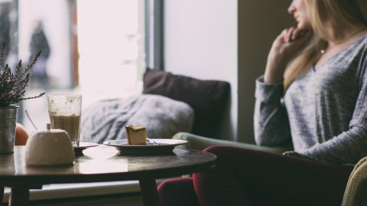 woman in cafe, solo travel tips
