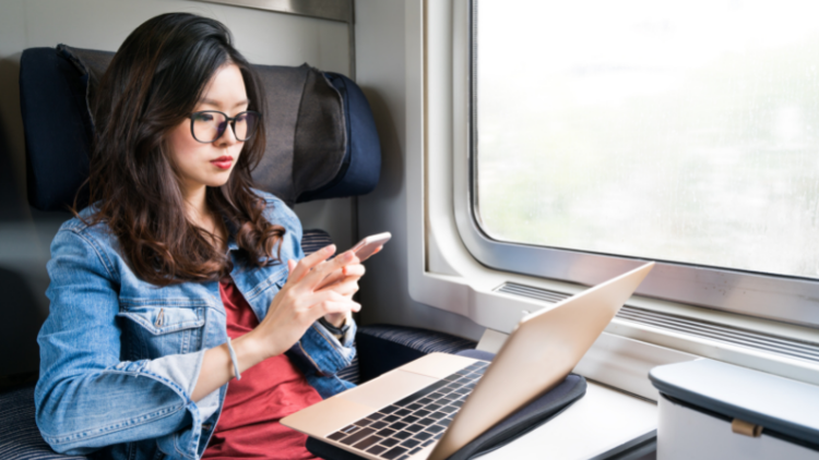 woman on train with laptop, solo business travel