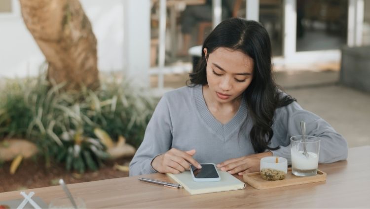 A VPN for travel is important if you will be accessing free Wi-Fi in cafes, like this woman.