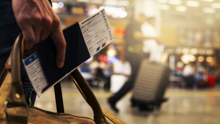 A traveler holding a boarding pass for a flight for their solo dream trip.
