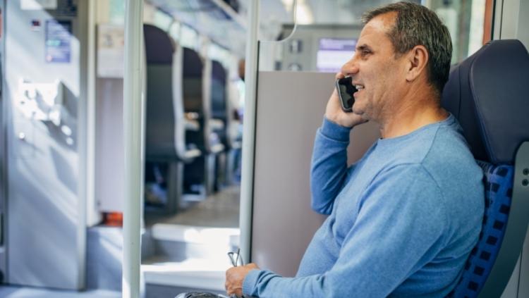 man on train talking on mobile phone