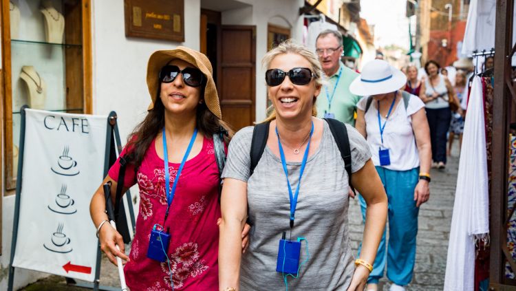 female travelers on their first solo trip walking throgh a city on an audio tour