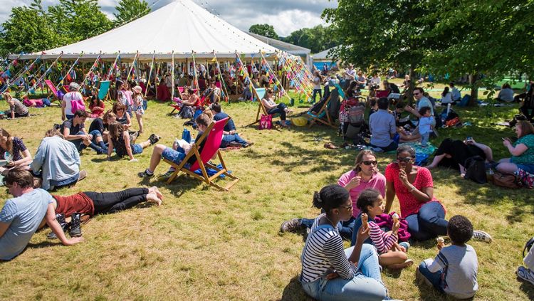 Pessoas sentadas ao sol, aproveitando o The Hay Festival no País de Gales