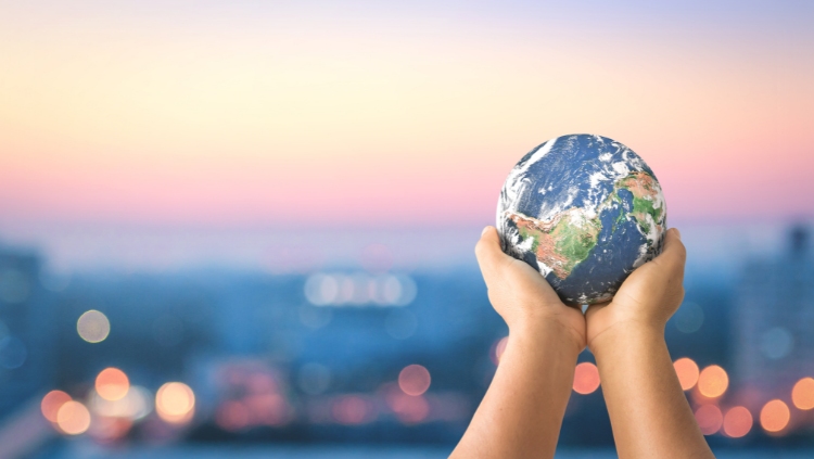 Two hands holding a globe with a blurred background