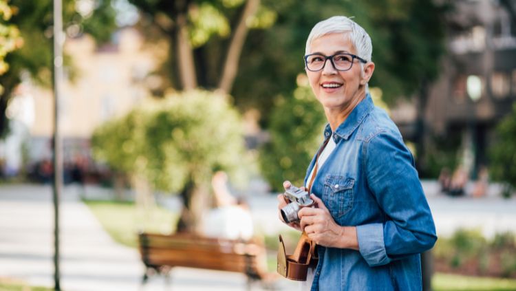 woman with camera enjoying solo travel in retirement