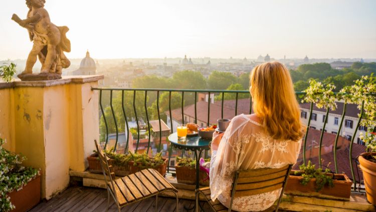 woman sitting on apartment balcony drinking coffee