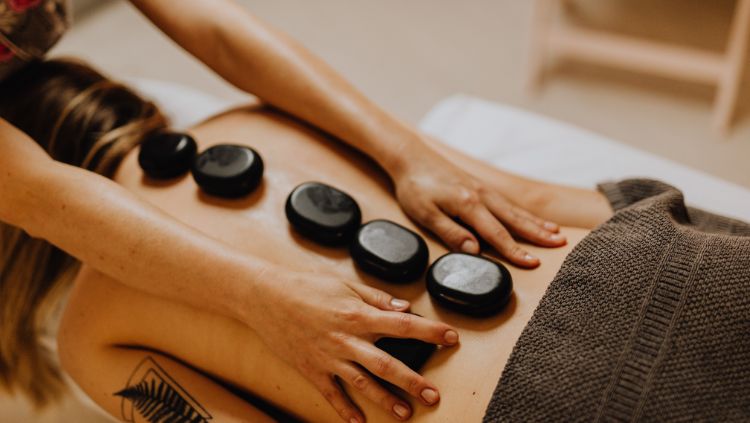 woman indulging in solo travel for self-care through hot stone massage