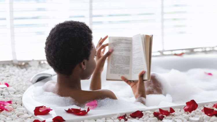 woman reading book in bath