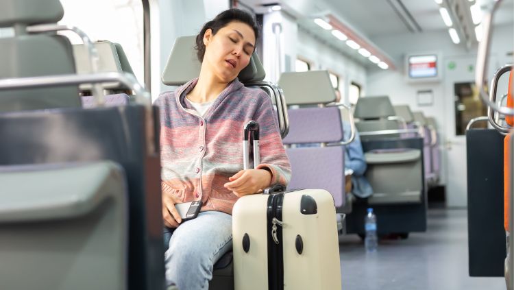 image, woman asleep with suitcase, travel fatigue