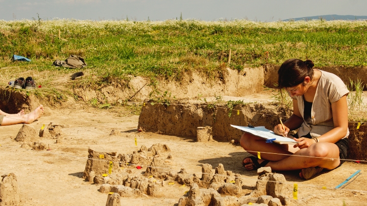 Woman taking notes during a volunteer travel assignment on an archeological dig