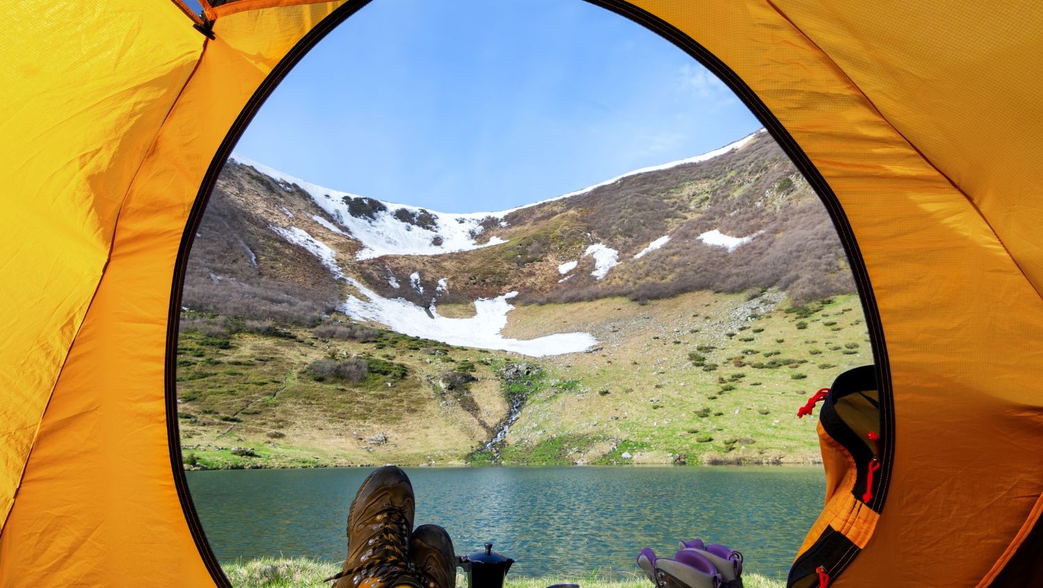 This view of a lake from inside a tent is what awaits you on your first time camping solo
